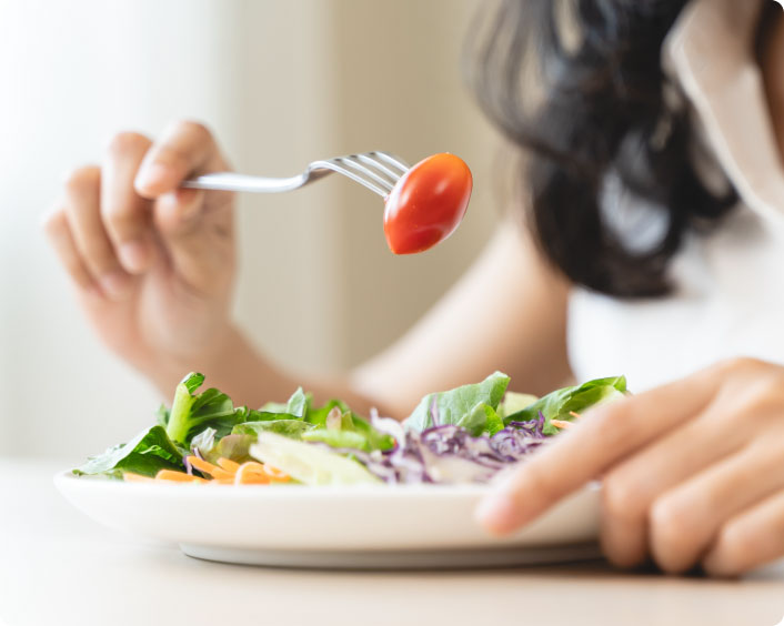 Woman eating a salad recovering from fundoplication