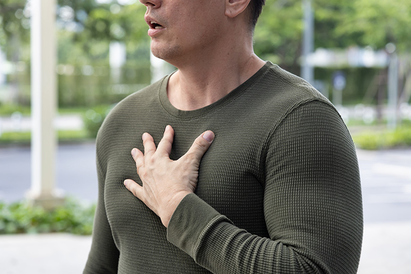 Man experiencing acid reflux with a burning sensation in the chest