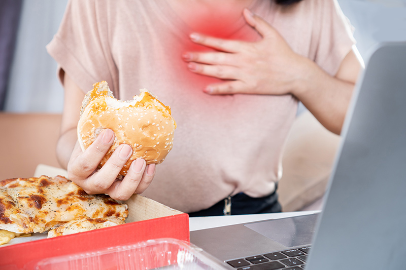 Woman experiencing acid reflux symptoms while eating