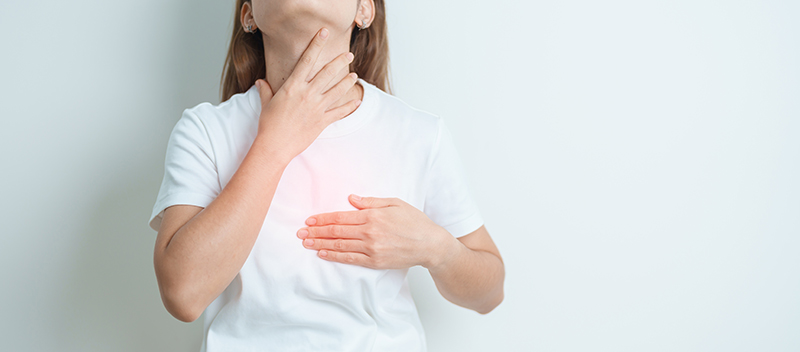 Female patient experiencing a sore throat caused by acid reflux.