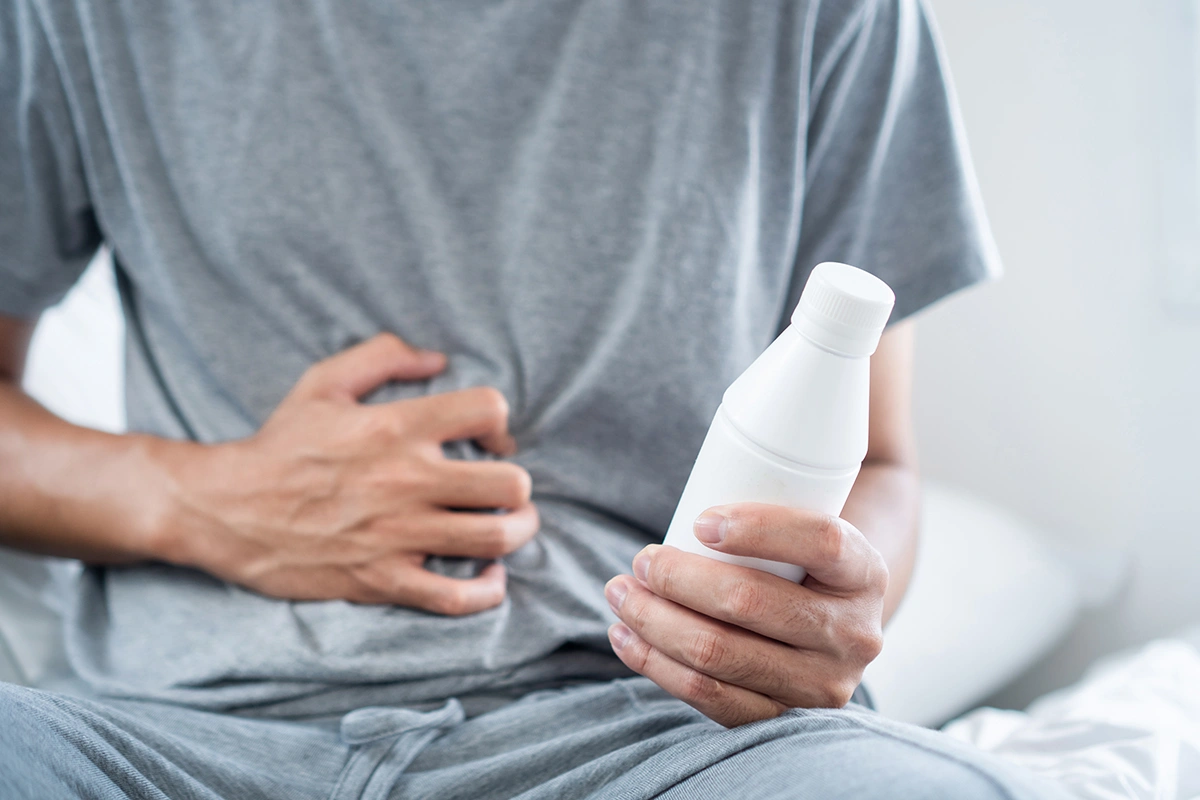 A man holding a bottle of medication for acid reflux