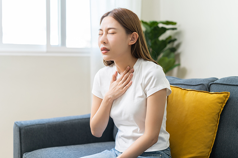 Woman experiencing acid reflux symptoms and discomfort